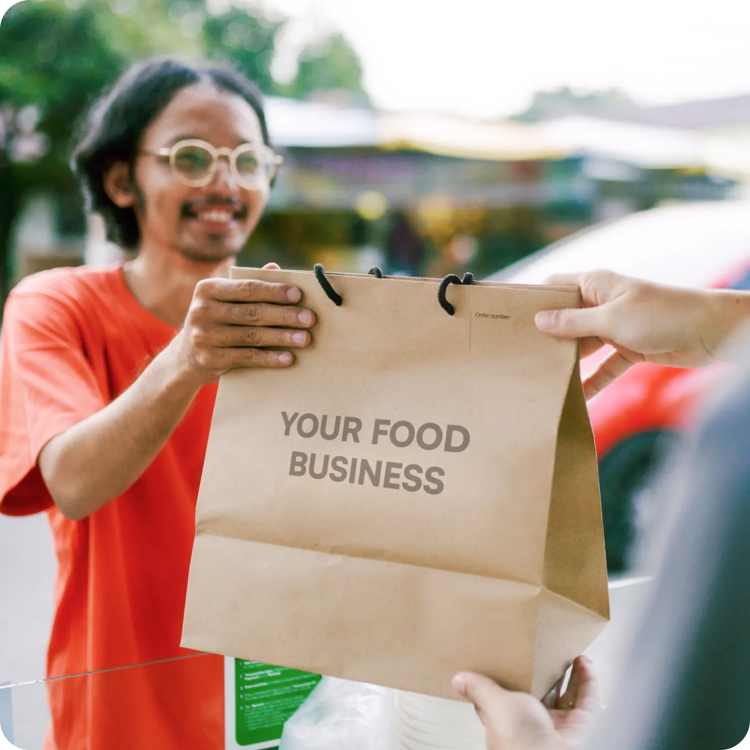 Man dropping off a food delivery in brown bag.